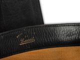 a close up of a black and tan bag with a brown handle