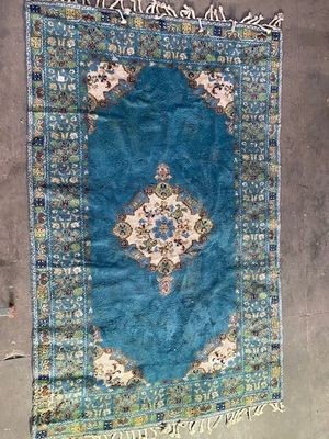Le tapis posé au sol est bleu et présente un motif en médaillon.