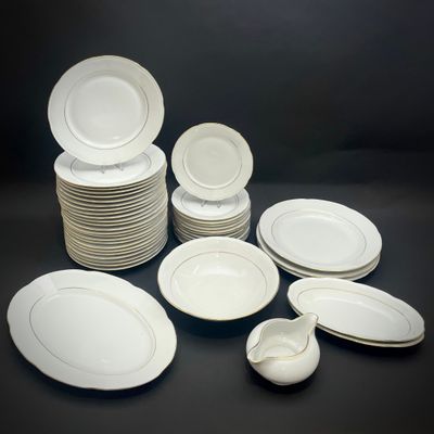 beaucoup d'assiettes et de bols blancs sur la table
