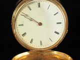 a gold pocket watch with roman numerals on it