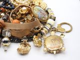 a pile of assorted jewelry on a white surface