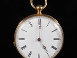 une montre de poche en or avec des chiffres romains sur le cadran