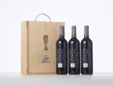 three bottles of wine in front of a wooden box