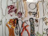 a lot of necklaces and bracelets hanging on a wall