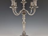 a silver plated candelab with five candles on a stand