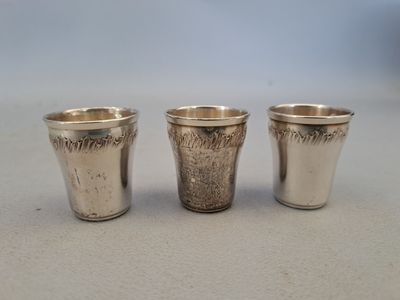 deux verres à shot en argent posés l'un à côté de l'autre sur une table