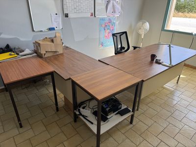 une photo d'un bureau dans une pièce très encombrée