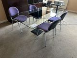 une table en verre entourée de chaises violettes au milieu de la pièce