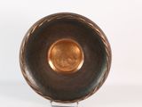 a metal bowl on a metal stand on a white surface