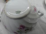 a white tea pot with a pink flower design on it