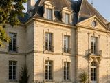 une photo d'une grande maison avec une pelouse devant