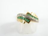 a close up of a gold ring with emeralds and diamonds