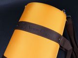 yellow and brown travel bag with brown strap on black background