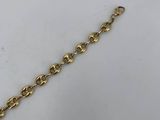 a close up of a gold chain on a white surface