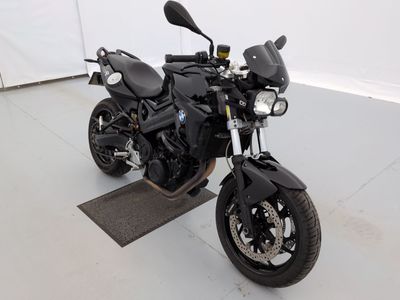 une photo d'une moto noire garée dans un garage