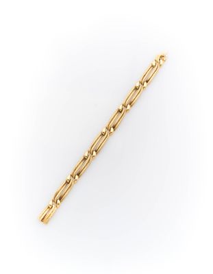 a gold plated bar bracelet with beads on a white background