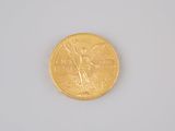 a gold coin with an angel on it on a white surface