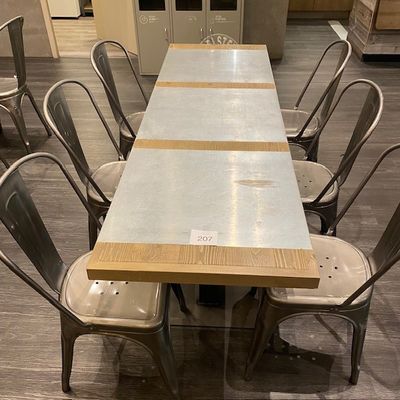 une longue table entourée de six chaises dans une pièce