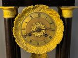 a clock that is sitting on a stand in the room