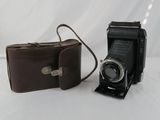two cameras sitting next to each other on a white surface