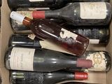 plusieurs bouteilles de vin dans un carton posé sur le sol