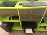 a computer desk with a keyboard and a printer on it