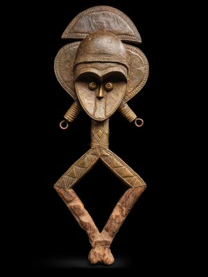 une image représentant une sculpture en bois d'un homme portant un casque sur la tête