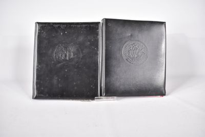 deux livres noirs posés l'un sur l'autre sur une surface blanche