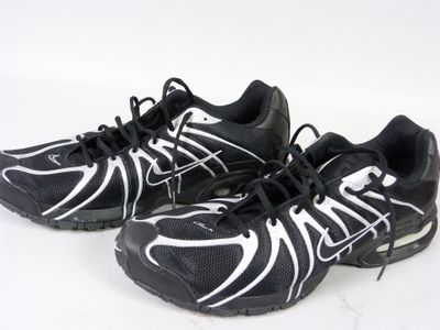 une paire de chaussures de course noires et blanches posées sur une surface blanche