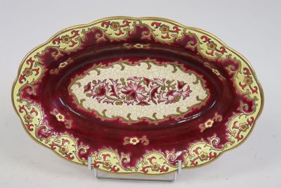 une image représentant une assiette rouge et dorée ornée d'un motif floral