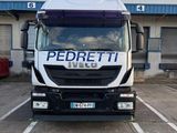 un camion garé sur un parking, avec un bâtiment en arrière-plan