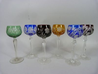 six wine glasses are lined up in a row on a white surface