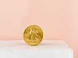 gold coin sitting on top of a white marble block
