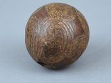 une vieille boule en bois posée sur une surface grise