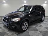 une photo d'un SUV bmw noir garé dans un garage