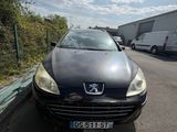 une voiture noire garée dans un parking à côté d'un bâtiment