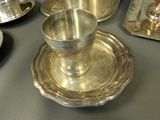 a silver plate with a silver cup and saucer on it