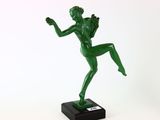 une statue verte représentant une femme tenant une raquette de tennis, posée sur un socle noir