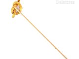 a close up of a gold pin with a knot on it