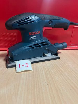une ponceuse Black & Decker posée sur une table en bois
