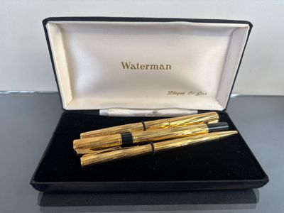two pens sitting in a black box on a table