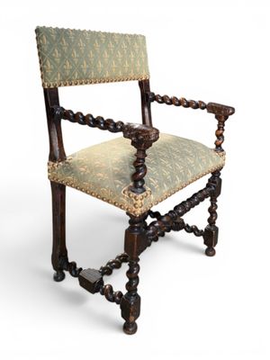 an old wooden chair with a green upholstered seat