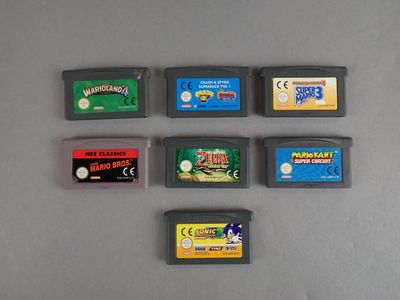 Plusieurs cartouches de jeux Nintendo sont alignées sur une table