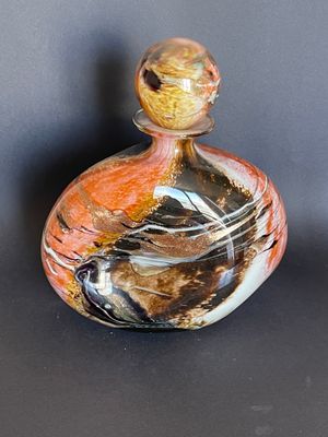 a small glass bottle with a colorful design on it