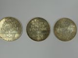 trois types de pièces différents posés sur une surface blanche