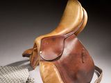 a saddle and a cloth on a white surface