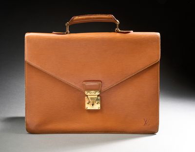 a brown briefcase sitting on top of a table next to a black background