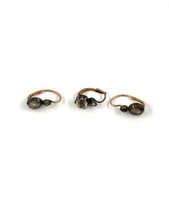 three gold rings with black stones on them on a white surface