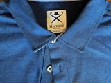 the blue shirt is sitting on a wooden table next to a pair of scissors