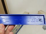 a person holding a blue ticket in front of a box